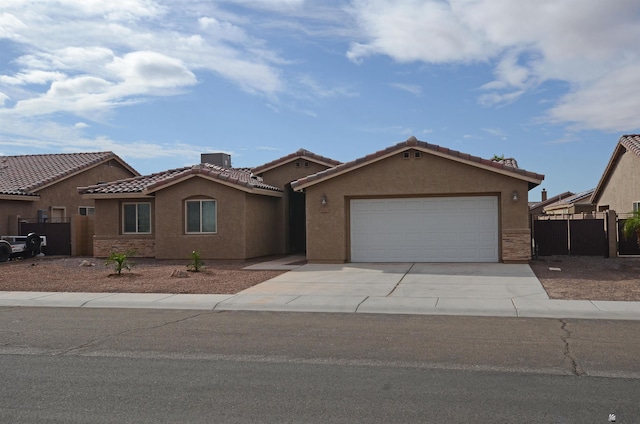 view of front of property with concrete driveway, fence, and stucco siding