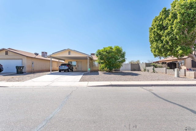 view of front of house with driveway, fence, and an attached carport