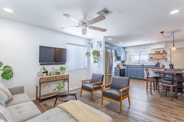 living area with baseboards, visible vents, wood finished floors, and recessed lighting