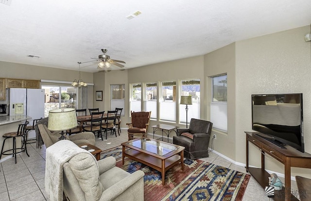 tiled living room featuring ceiling fan with notable chandelier