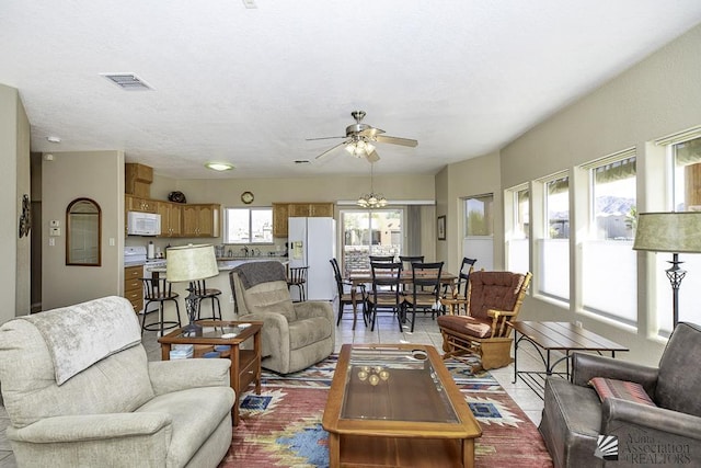 tiled living room featuring ceiling fan and sink