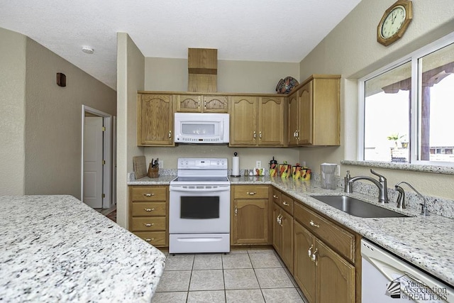 kitchen featuring light stone countertops, white appliances, sink, and light tile patterned floors