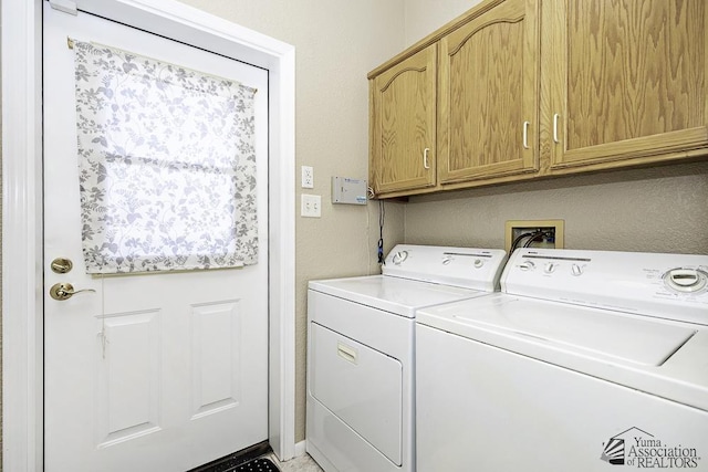 washroom featuring washer and clothes dryer and cabinets