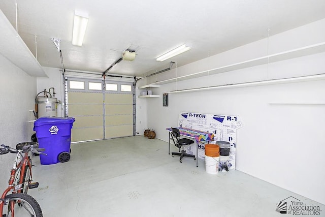 garage with electric panel, a garage door opener, and water heater