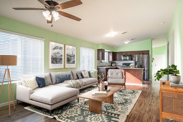 living room with ceiling fan, vaulted ceiling, and dark hardwood / wood-style floors