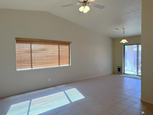 tiled spare room with a textured ceiling, ceiling fan, and lofted ceiling