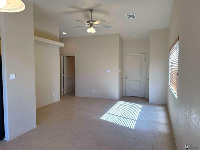 tiled spare room featuring ceiling fan