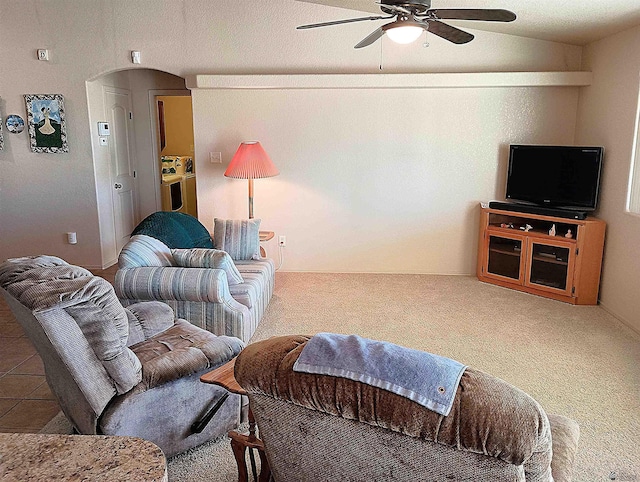 carpeted living room with ceiling fan and lofted ceiling