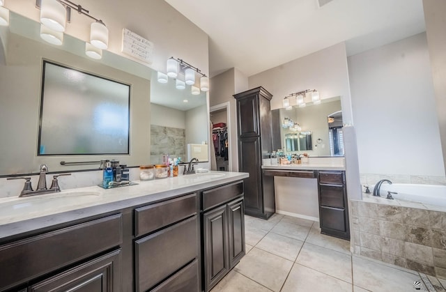 bathroom with tile patterned flooring, vanity, and tiled bath