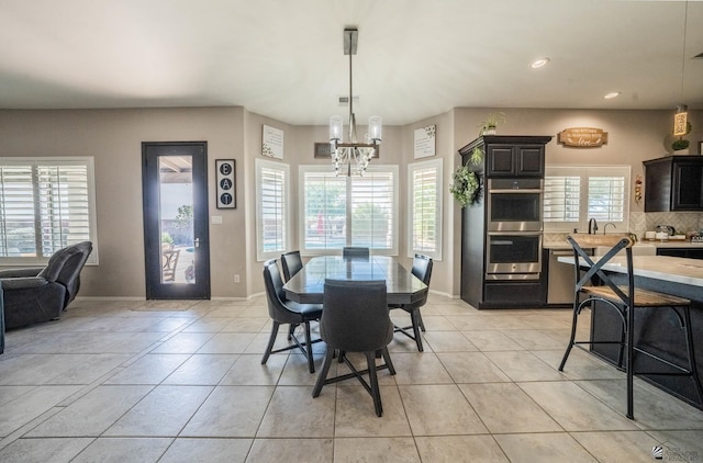 tiled dining room featuring an inviting chandelier