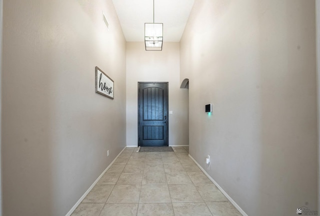 doorway to outside with a high ceiling and light tile patterned flooring