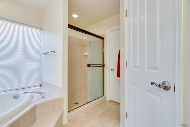 bathroom featuring a garden tub, a shower stall, and tile patterned floors