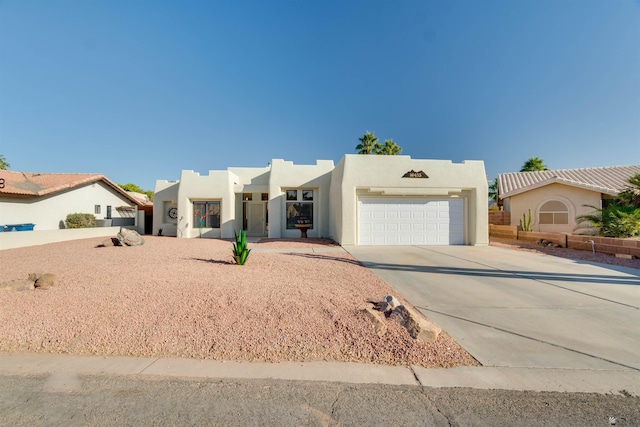 southwest-style home with a garage, driveway, and stucco siding