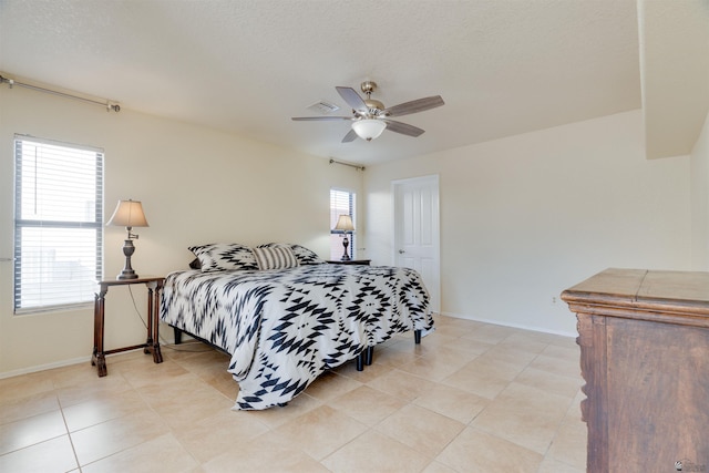 bedroom with baseboards, visible vents, and ceiling fan