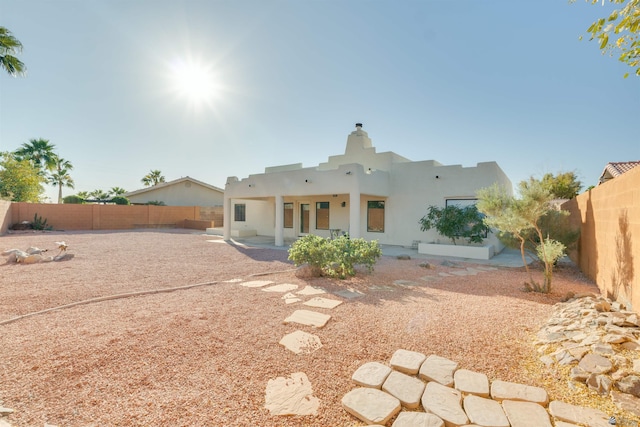 rear view of house featuring a patio area, a fenced backyard, and stucco siding