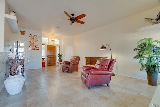 living area featuring ceiling fan and baseboards