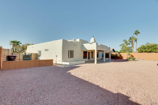 rear view of property with a patio, a fenced backyard, and stucco siding