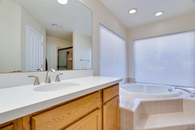 bathroom featuring visible vents, vanity, a shower stall, a bath, and recessed lighting