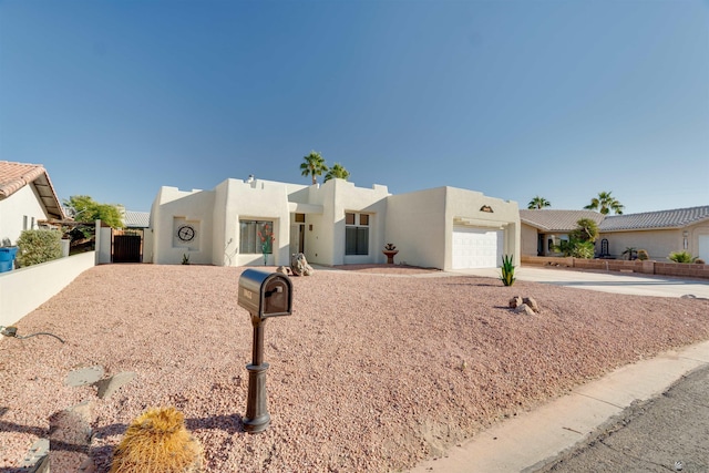 southwest-style home featuring an attached garage, concrete driveway, and stucco siding