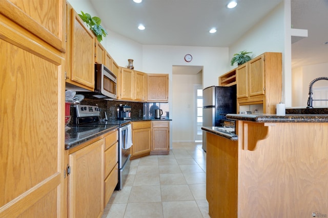 kitchen featuring light tile patterned floors, a peninsula, stainless steel appliances, backsplash, and recessed lighting