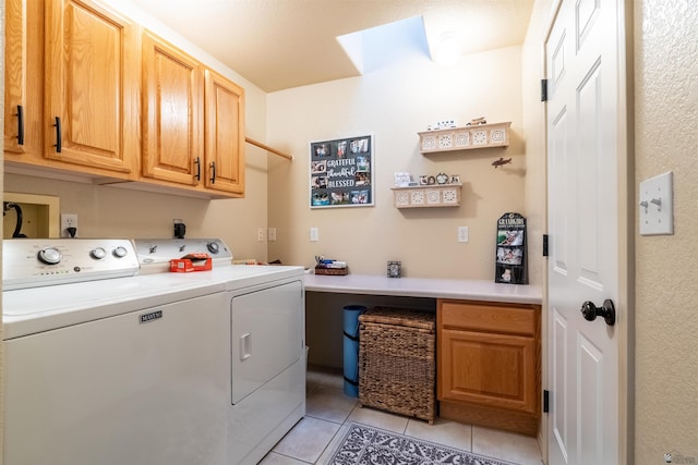 washroom with cabinets, washer and dryer, and light tile patterned floors