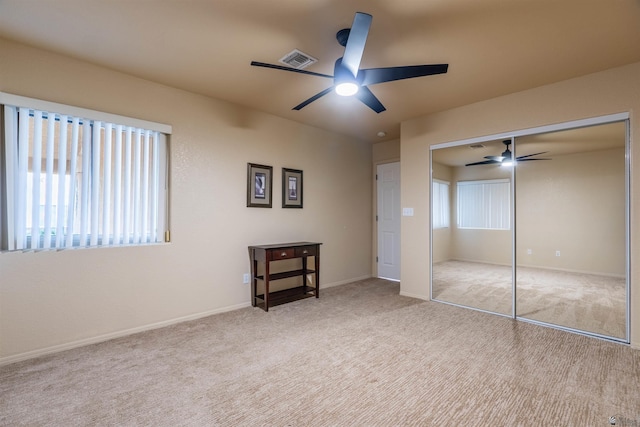 unfurnished bedroom with multiple windows, a closet, and light carpet