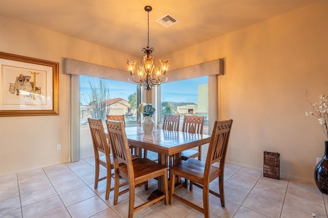 tiled dining room featuring an inviting chandelier