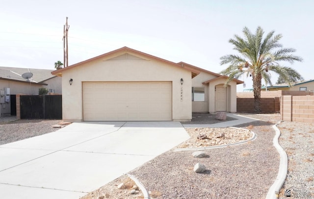 ranch-style house featuring concrete driveway, fence, an attached garage, and stucco siding