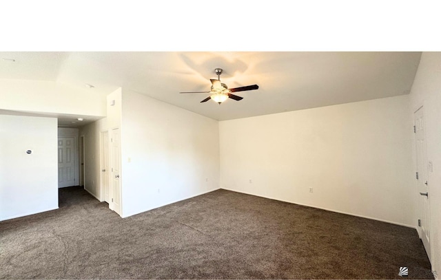 empty room with dark carpet, lofted ceiling, and ceiling fan