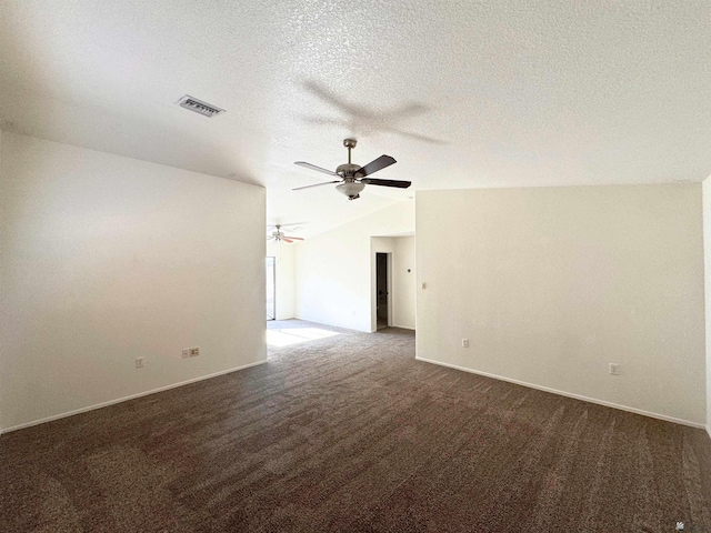 unfurnished room with visible vents, a ceiling fan, vaulted ceiling, a textured ceiling, and dark carpet