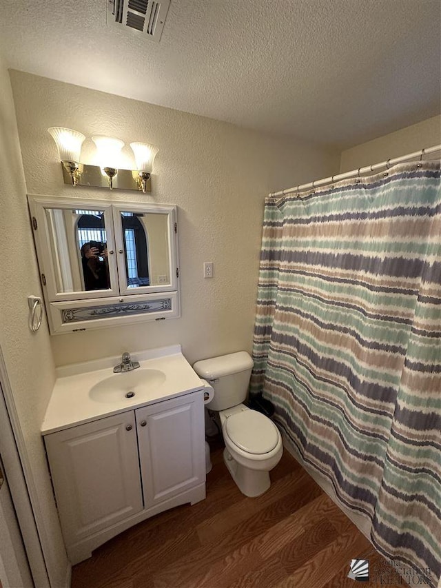 bathroom with vanity, a shower with curtain, hardwood / wood-style flooring, toilet, and a textured ceiling