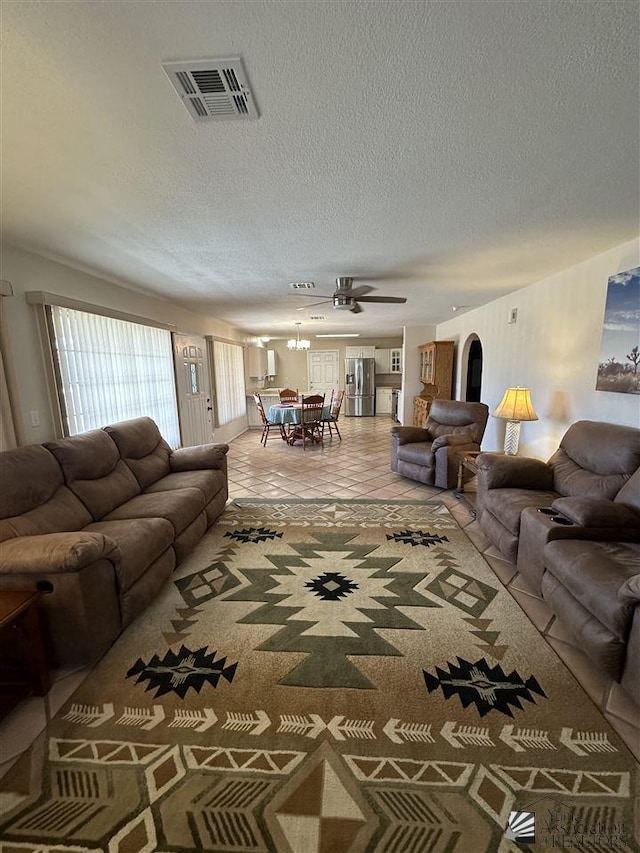 living room featuring a textured ceiling and ceiling fan