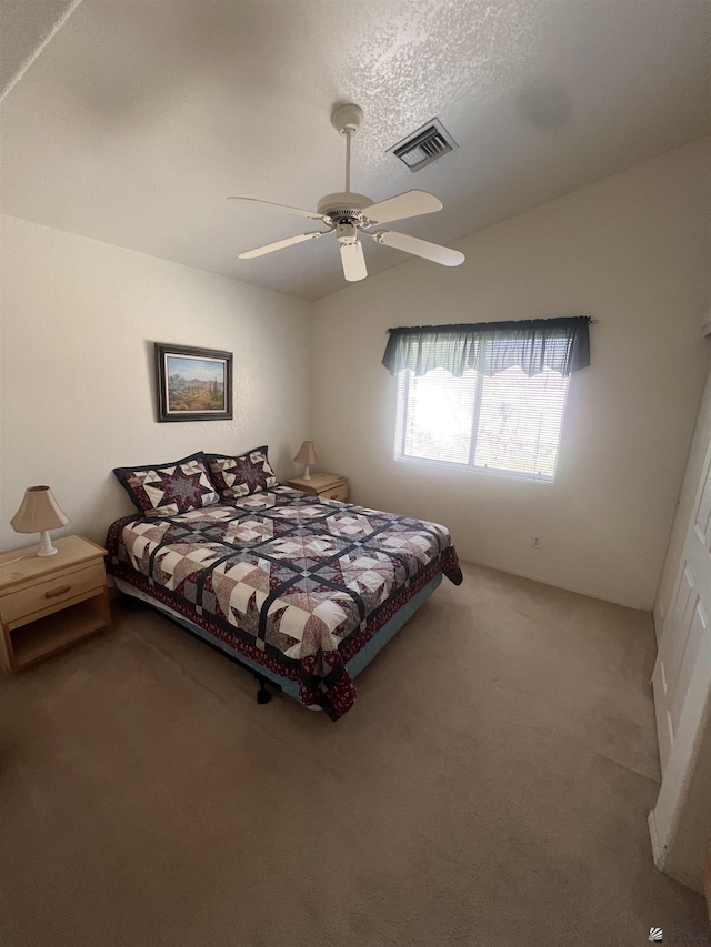 bedroom featuring visible vents, vaulted ceiling, carpet flooring, a textured ceiling, and a ceiling fan