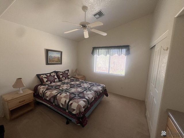 carpeted bedroom with lofted ceiling, a ceiling fan, and visible vents