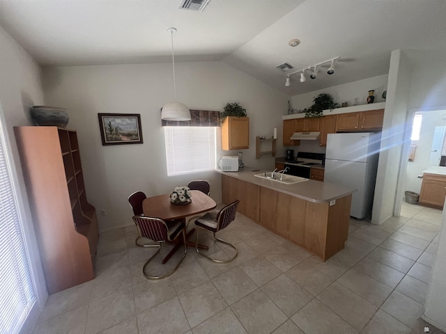 kitchen with freestanding refrigerator, a peninsula, light countertops, range, and vaulted ceiling