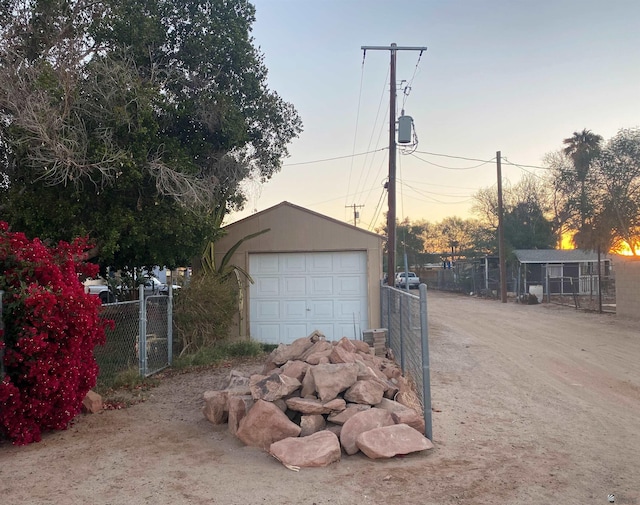 view of garage at dusk