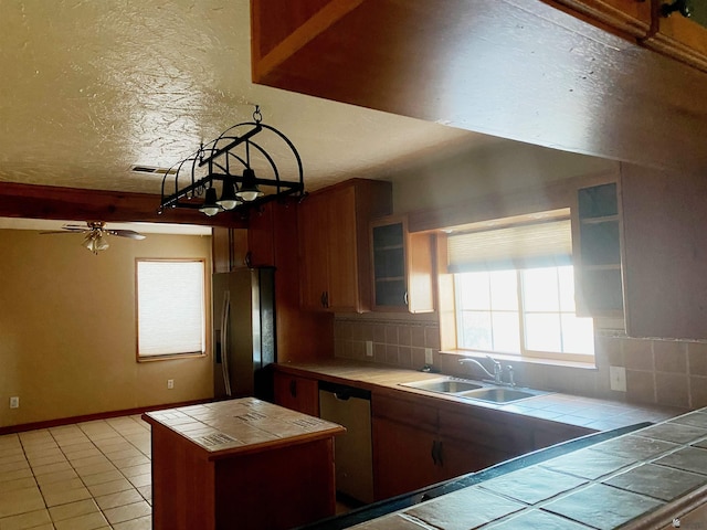 kitchen with ceiling fan, sink, tasteful backsplash, tile countertops, and appliances with stainless steel finishes