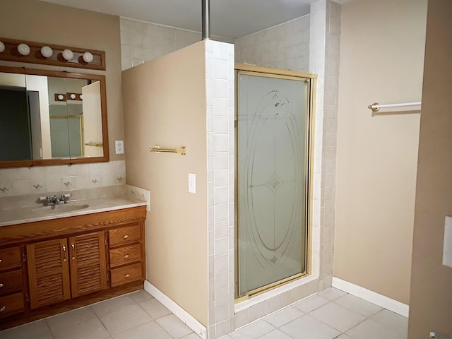 bathroom with tile patterned flooring, vanity, tasteful backsplash, and walk in shower