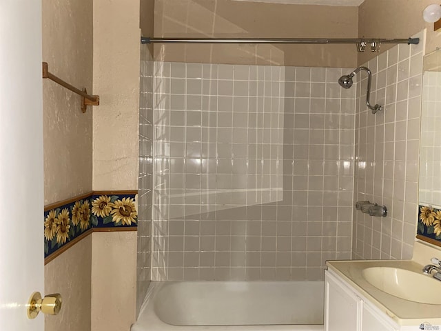 bathroom featuring vanity and tiled shower / bath