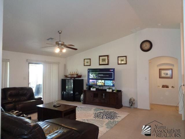 living room featuring ceiling fan, light carpet, and vaulted ceiling