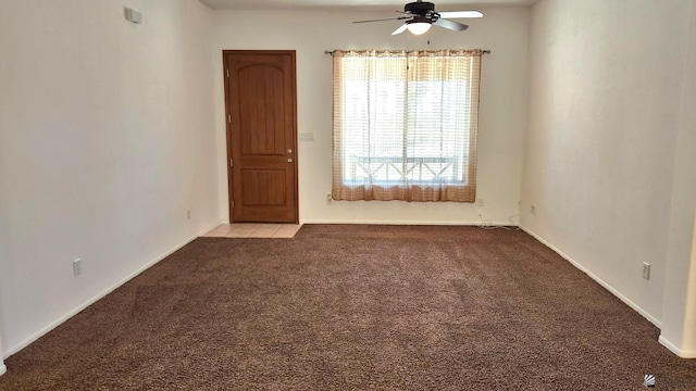 spare room featuring light carpet and a ceiling fan