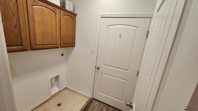 laundry area featuring cabinet space, electric dryer hookup, baseboards, and tile patterned floors