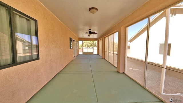 unfurnished sunroom with a ceiling fan