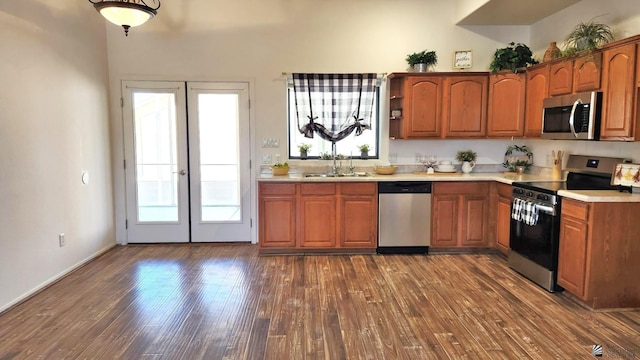 kitchen featuring stainless steel appliances, dark wood-style flooring, a sink, light countertops, and french doors