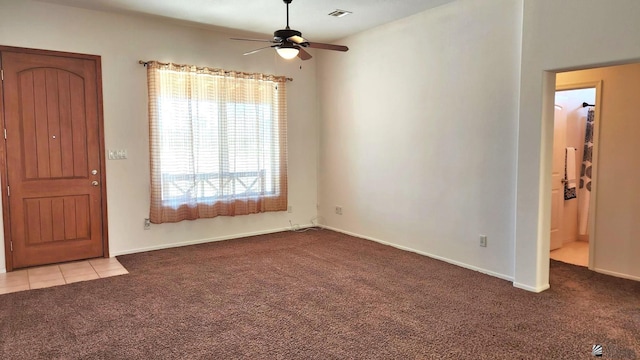 interior space featuring ceiling fan, light tile patterned floors, light carpet, visible vents, and baseboards