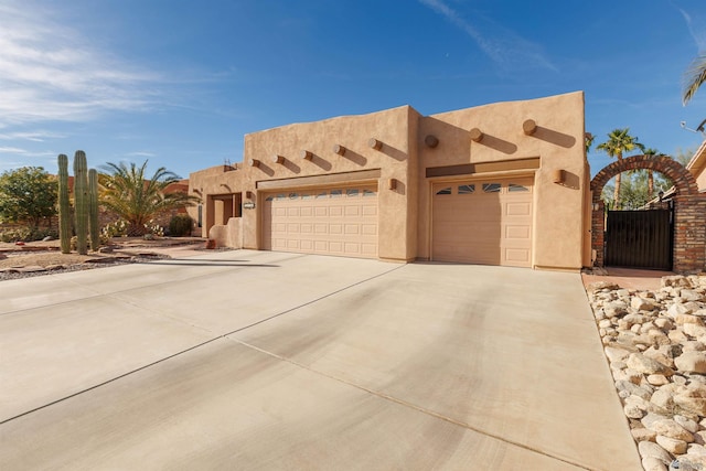 pueblo revival-style home with a garage