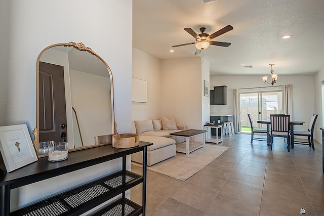 living room with ceiling fan with notable chandelier, light tile patterned flooring, and recessed lighting