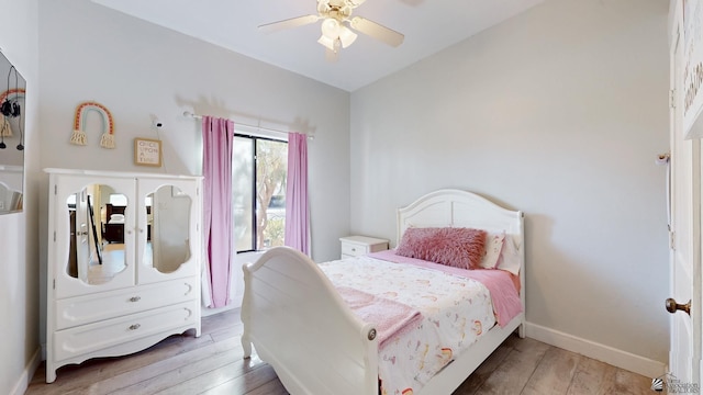 bedroom featuring a ceiling fan, baseboards, and wood finished floors