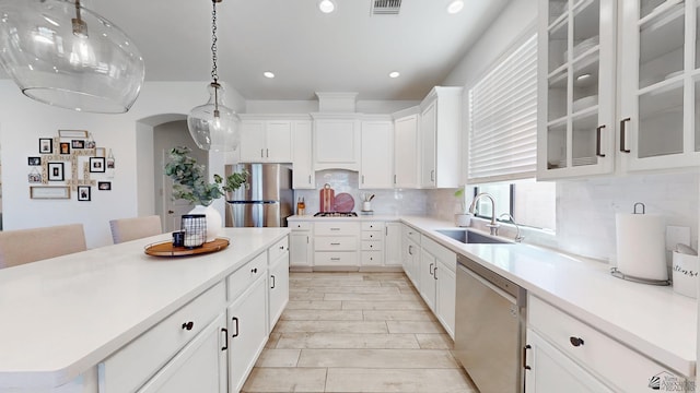 kitchen featuring a sink, stainless steel appliances, light countertops, and pendant lighting