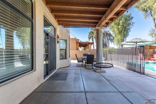 view of patio / terrace with fence, outdoor dining area, and a fenced in pool